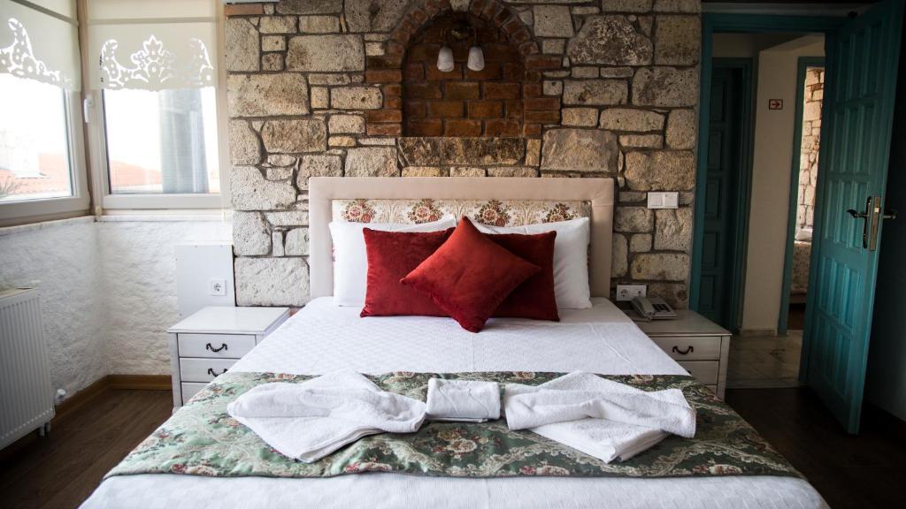 a bedroom with a bed with towels on it at Alacati Sardunya Hotel in Alaçatı