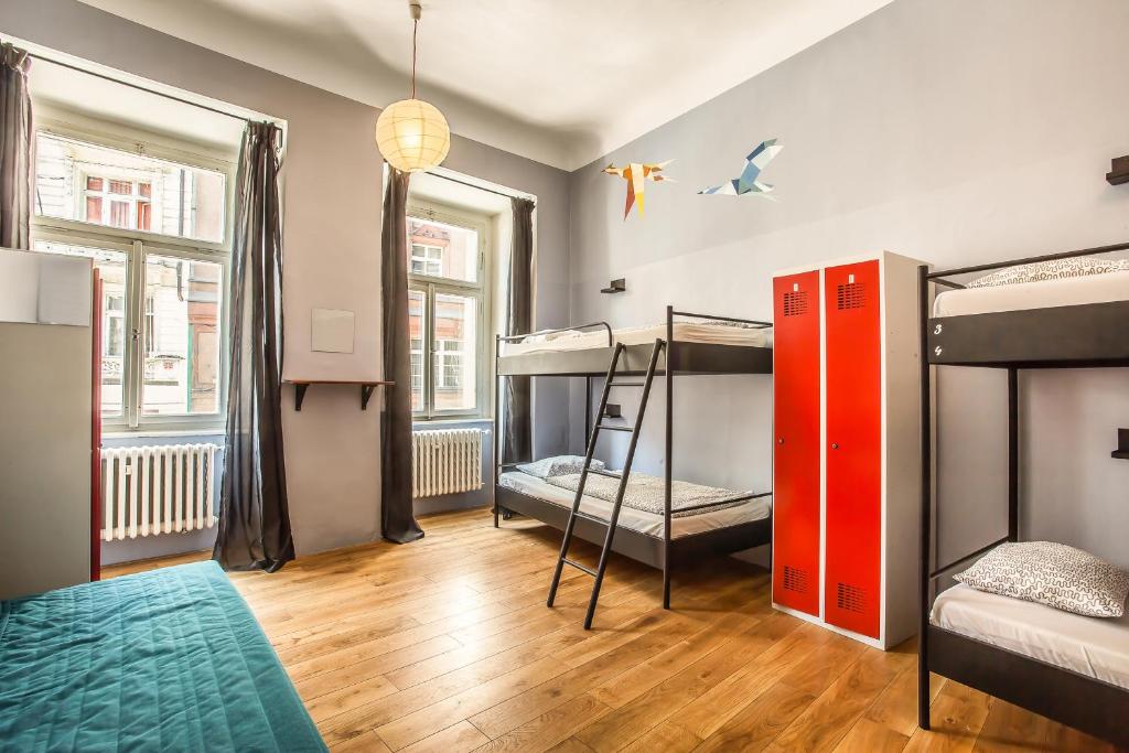 a room with three bunk beds and a red door at Ahoy! Hostel in Prague