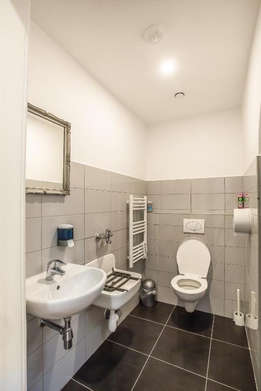 a bathroom with a white toilet and a sink at Ahoy! Hostel in Prague