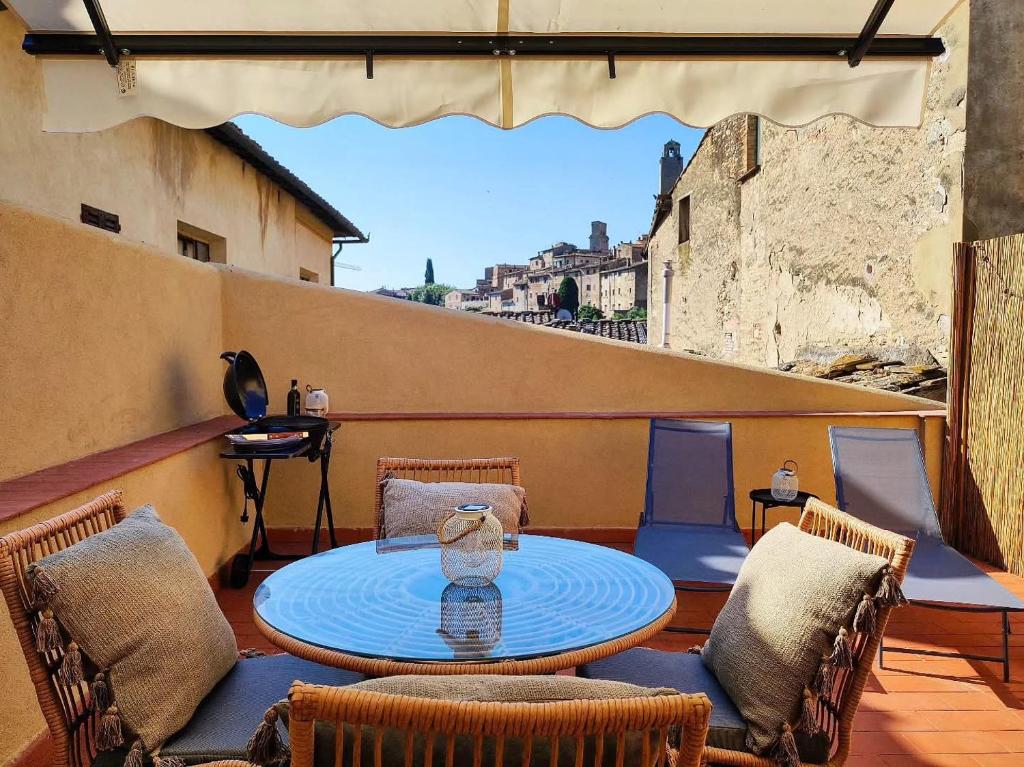 a patio with a table and chairs on a balcony at Terrazza San Martino San Gimignano Apartments in San Gimignano