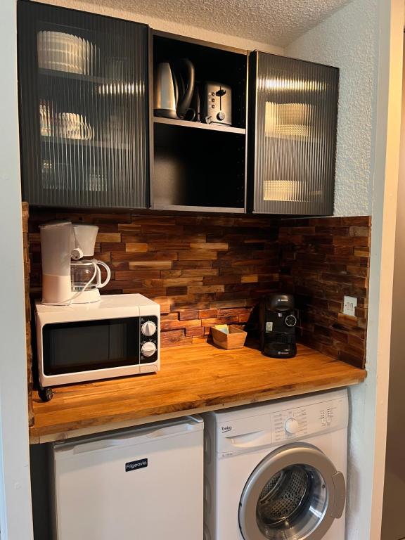 une cuisine avec un micro-ondes et un lave-linge dans l'établissement Studio COSY, à Saint-Chaffrey