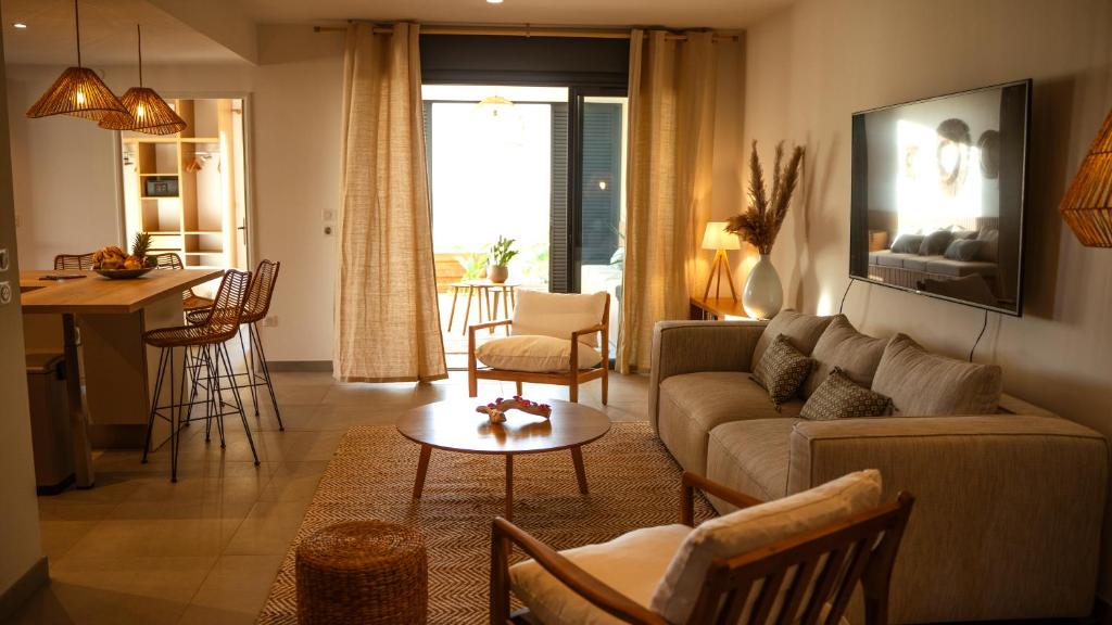 un salon avec un canapé et une table dans l'établissement La Palmeraie sur l'Océan, à La Saline les Bains