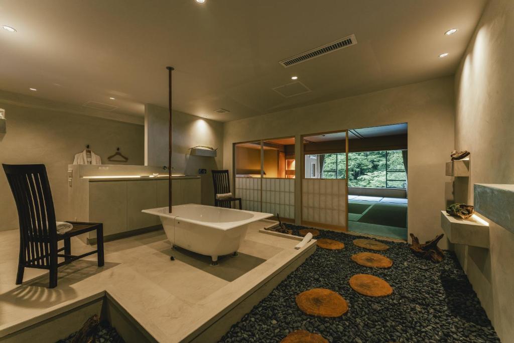 une salle de bains avec une grande baignoire et un lavabo dans l'établissement Myojinkan, à Matsumoto