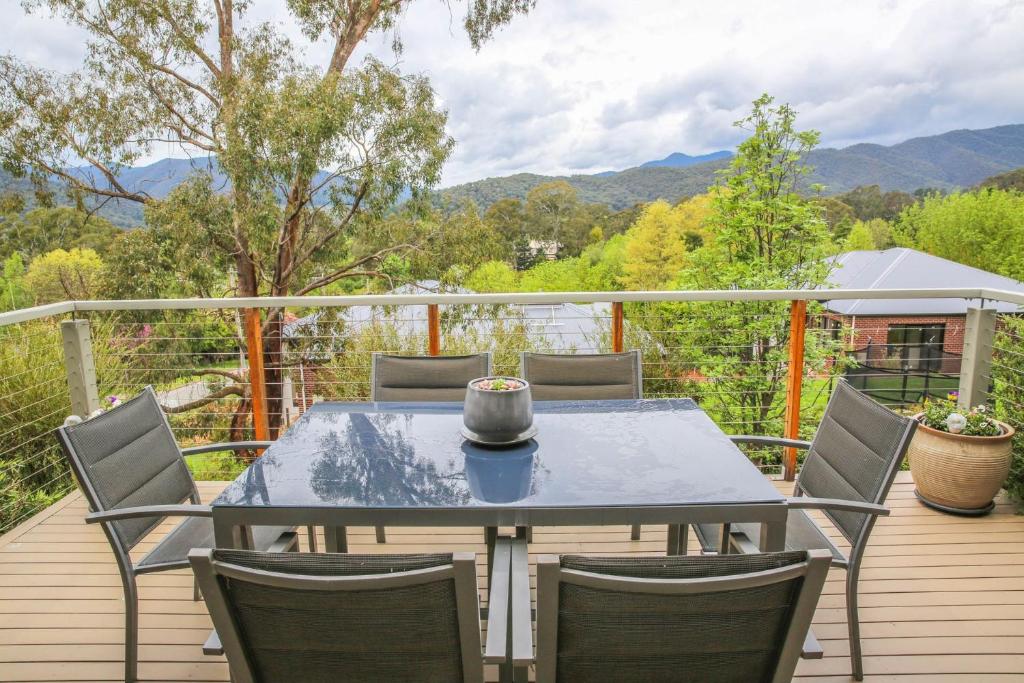 una mesa y sillas en una terraza con montañas al fondo en Valley Vista, en Bright