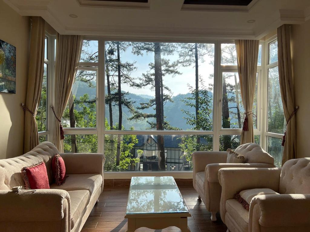 ein Wohnzimmer mit einem großen Fenster mit Aussicht in der Unterkunft Lan Anh Villas Resort in Da Lat