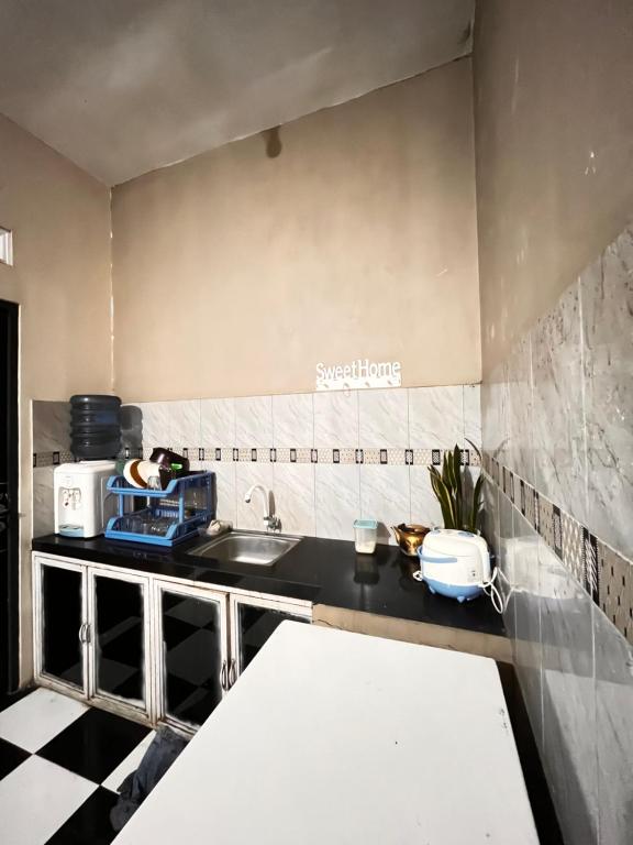 DiyengにあるHome Stay Pandawa Limaのシンクとカウンタートップのあるキッチン