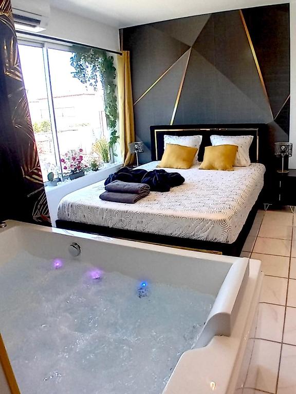 une chambre avec un lit et une baignoire dans l'établissement Luxury Beach Room, à Frontignan
