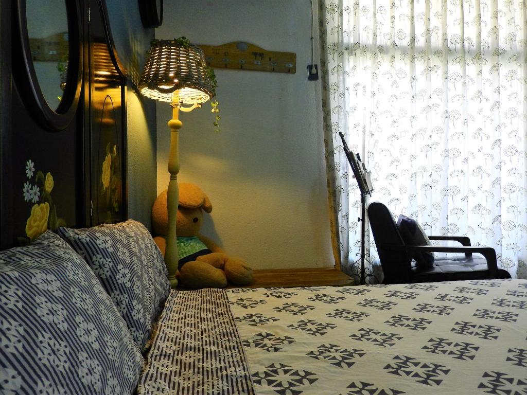 台南的住宿－House123巷，睡床旁边的地板上坐着泰迪熊