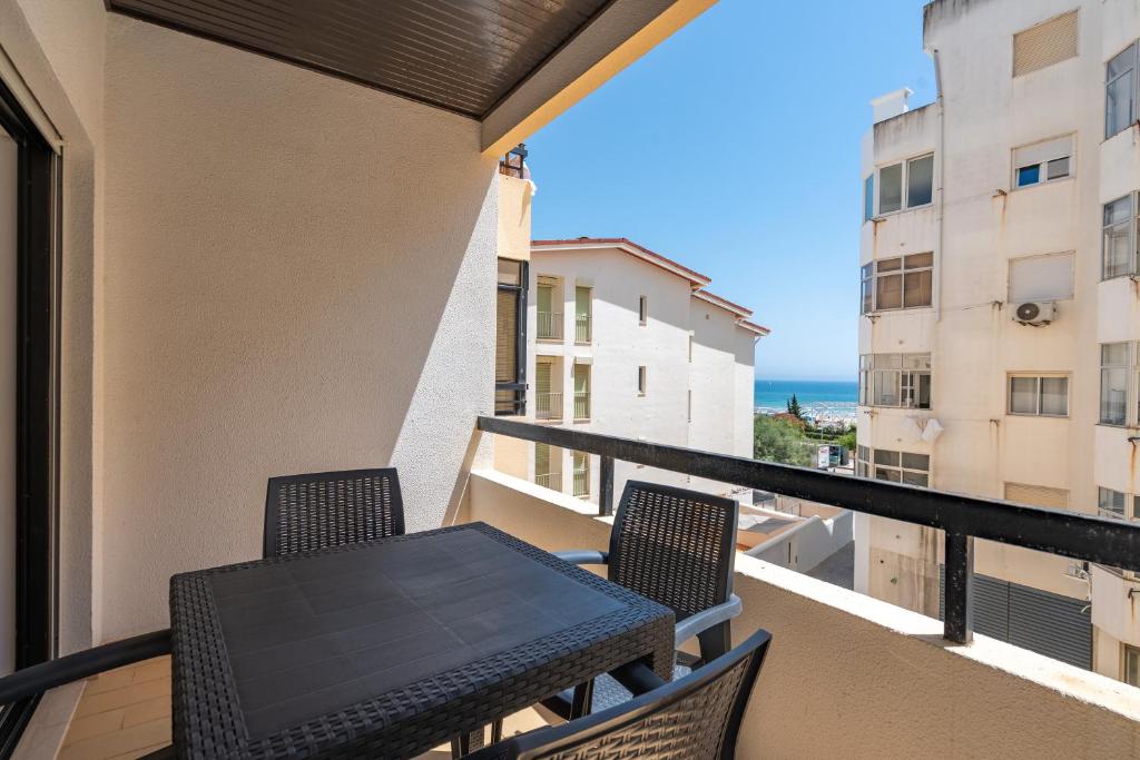 a balcony with a table and chairs and the ocean at Rocha Beach Apartment in Praia da Rocha