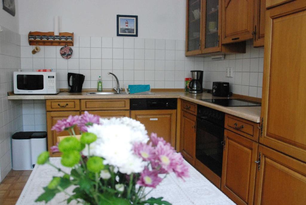 a kitchen with a vase of flowers on a counter at Ferienwohnung Braunschweiger Hof in Halberstadt