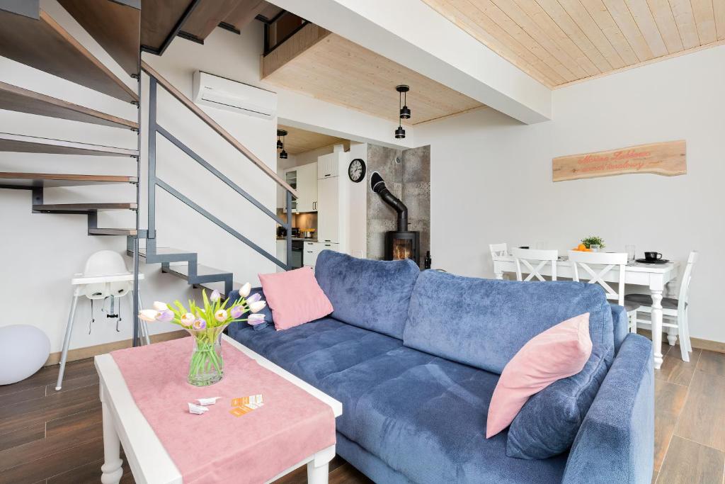 a living room with a blue couch and a table at Piekny Domek Koralowy w Lubkowie by Renters Prestige in Lubkowo