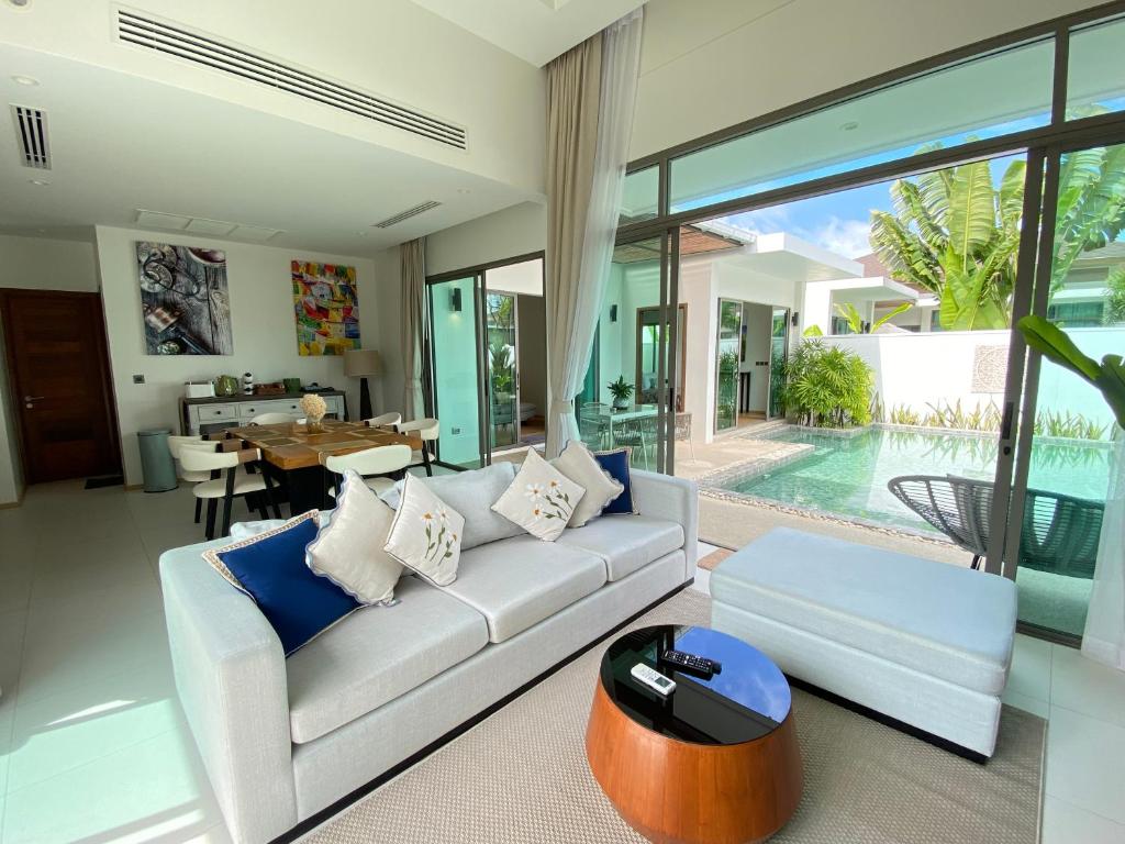 a living room with a white couch and a table at Tropical Shambala Grand Villa in Bang Tao Beach
