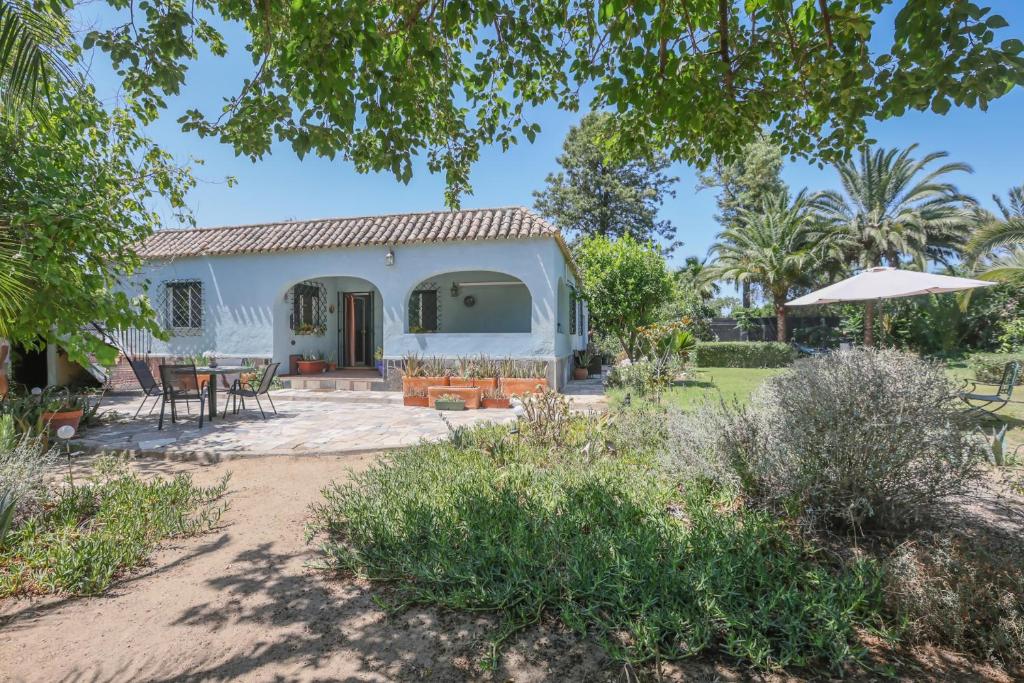 een huisje met een tafel en stoelen in een tuin bij Casa rural Villa Moral in El Arahal