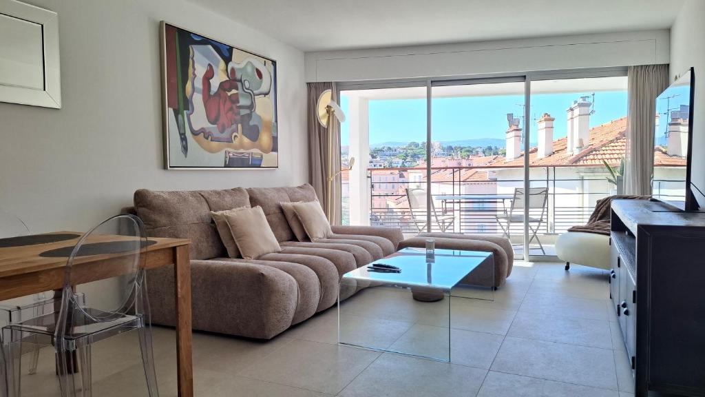 un salon avec un canapé et une table en verre dans l'établissement Cannes Centre - Villa Lérins - Cavell Suites - Walking Distance From Palais des Festivals and Beach - Free Parking - Perfect Location For Business And Holliday, à Cannes