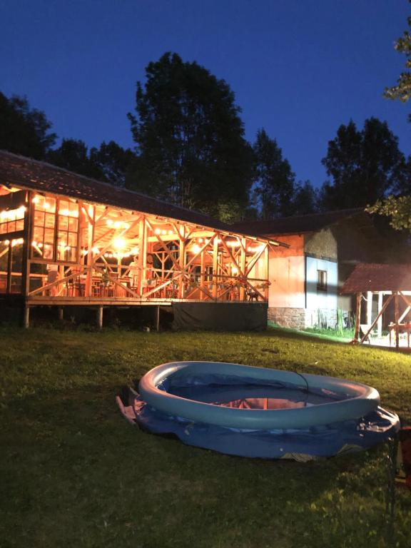 a fire pit in the grass in front of a building at Mesteceni Glamping in Nistoreşti
