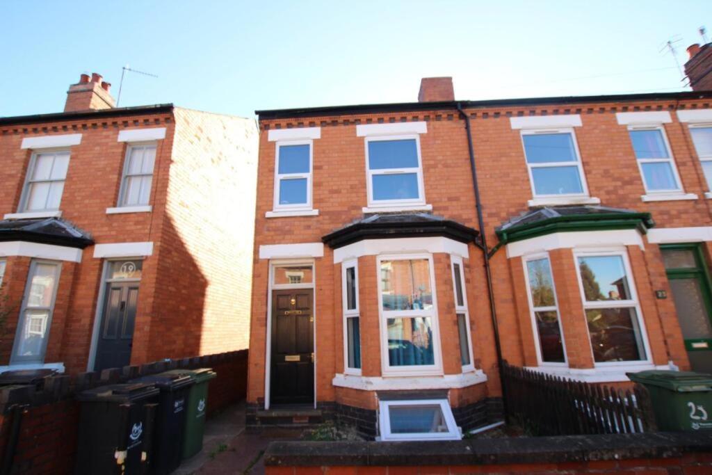 a red brick house with white trim on a street at 4 Double Bedroom House with Private Garden and Own Entrance in Henwick