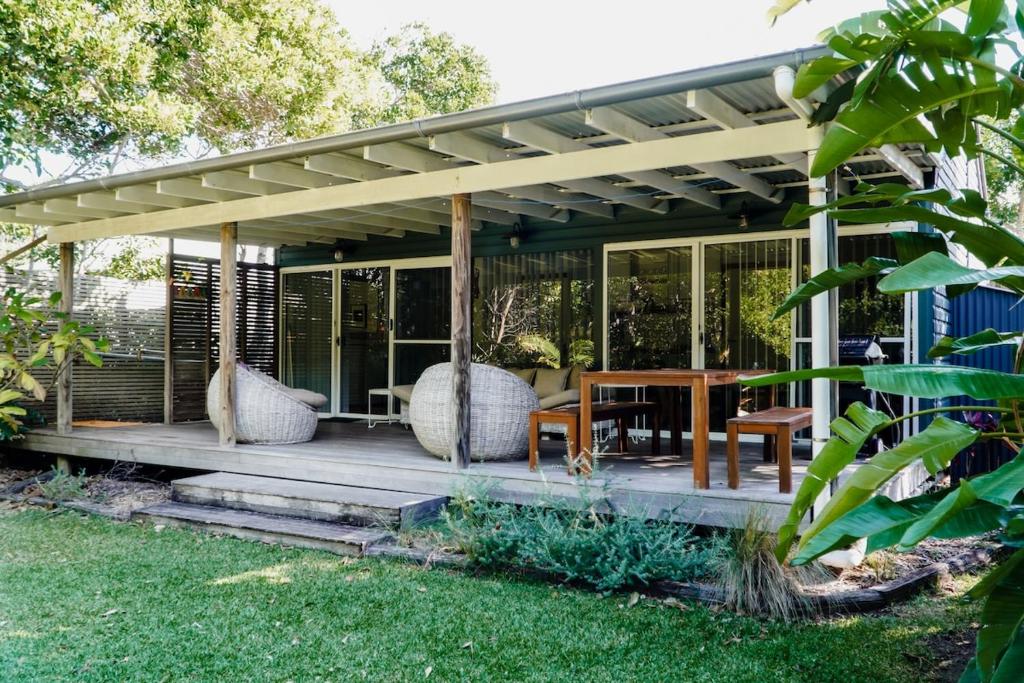een afgeschermde veranda met een tafel en stoelen bij #15 Tallow Sands - The Cabin in Suffolk Park