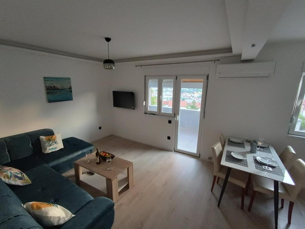 een woonkamer met een bank en een tafel bij Estrella Apartment Mostar in Mostar