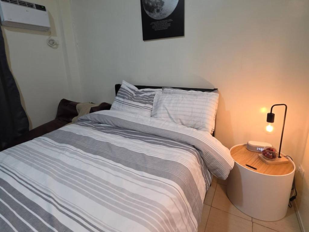 a bedroom with a large bed with a night stand at Pioneerwoodlands Mandaluyong Studio Unit in Manila