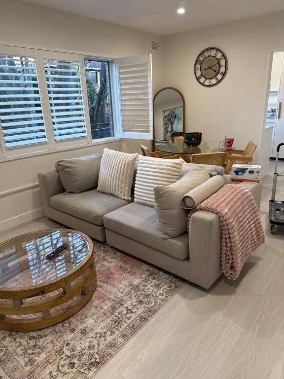 a living room with a couch and a coffee table at Coogee Treehouse in Sydney