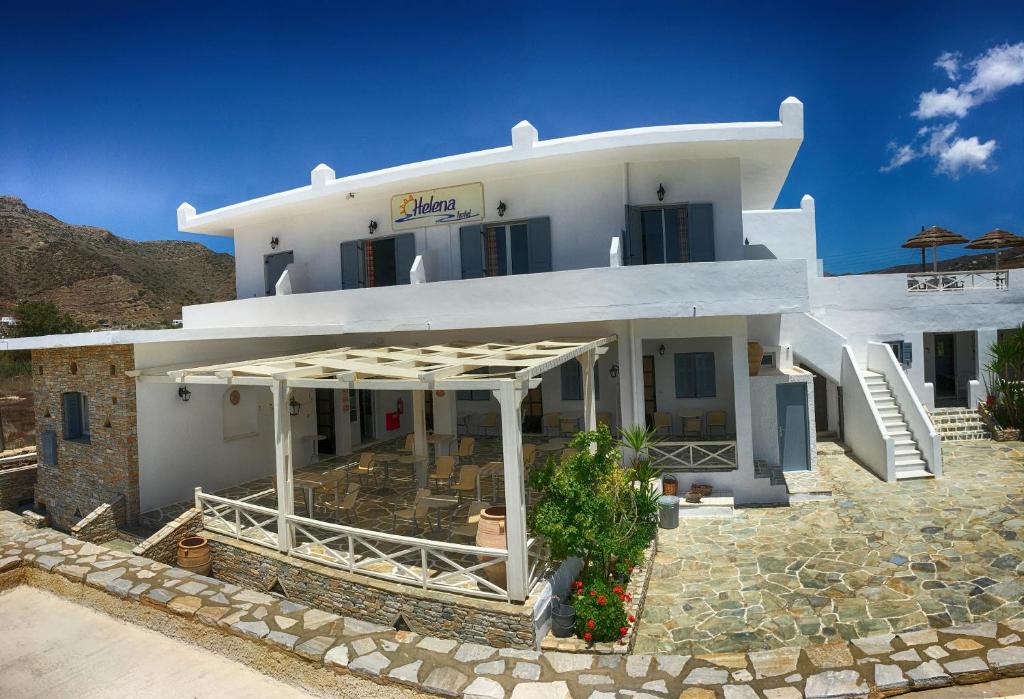 a large white house with a patio in front of it at Hotel Helena in Ios Chora