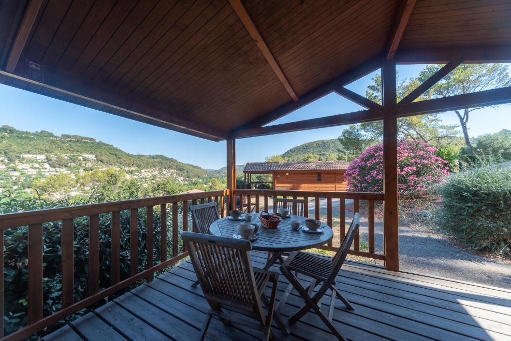 a table and chairs on a deck with a view at Lou Gatoun - Cottage Climatisé in Solliès-Toucas