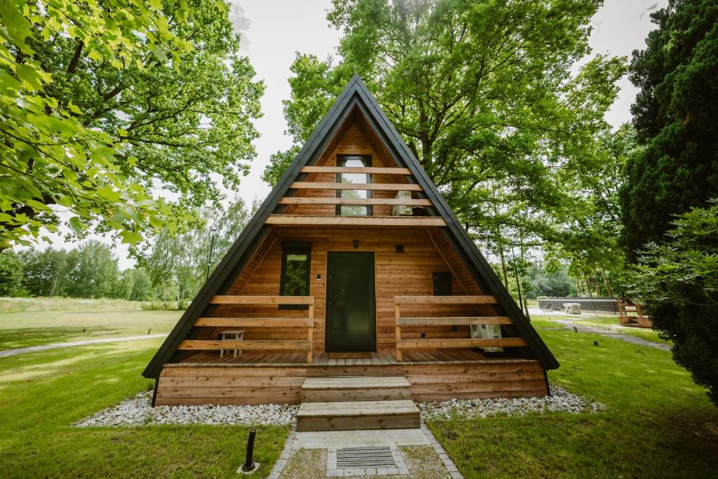 una pequeña cabaña de troncos con techo triangular en Ośrodek Wypoczynkowy Nad Leśną Wodą, en Bystrzyca
