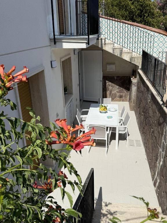 a patio with a white table and chairs on a balcony at Beach House Ponente in Erchie