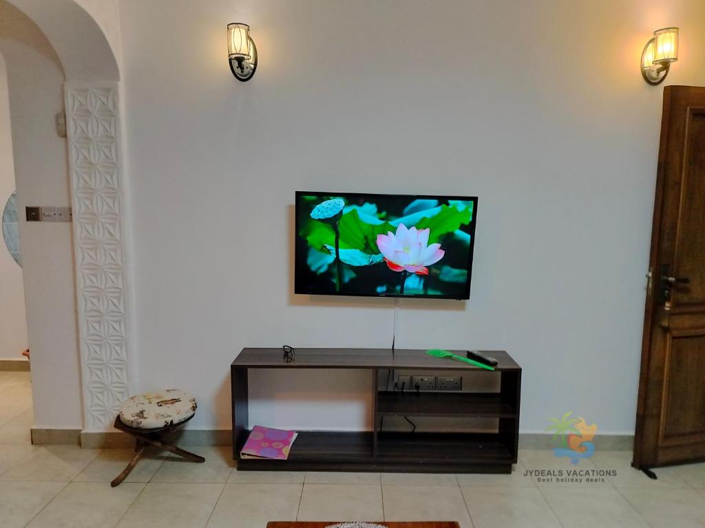a living room with a flat screen tv on a wall at 1 bedroom suite Diani in Ukunda Airport