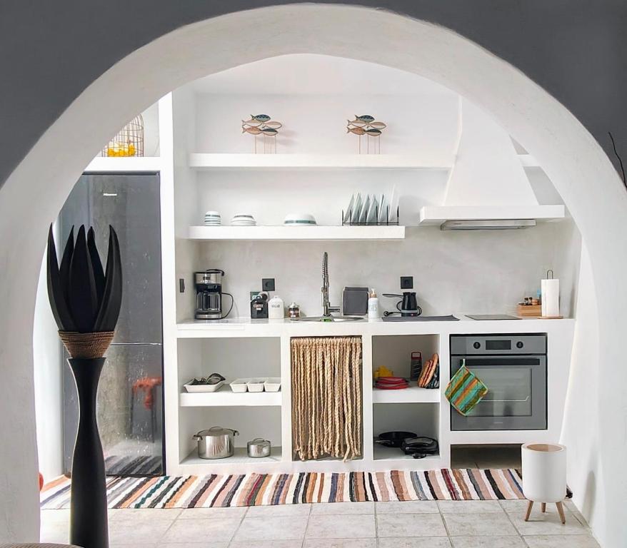 a kitchen with white shelves and a stove at Frida' s Mansion in Dhragoulás