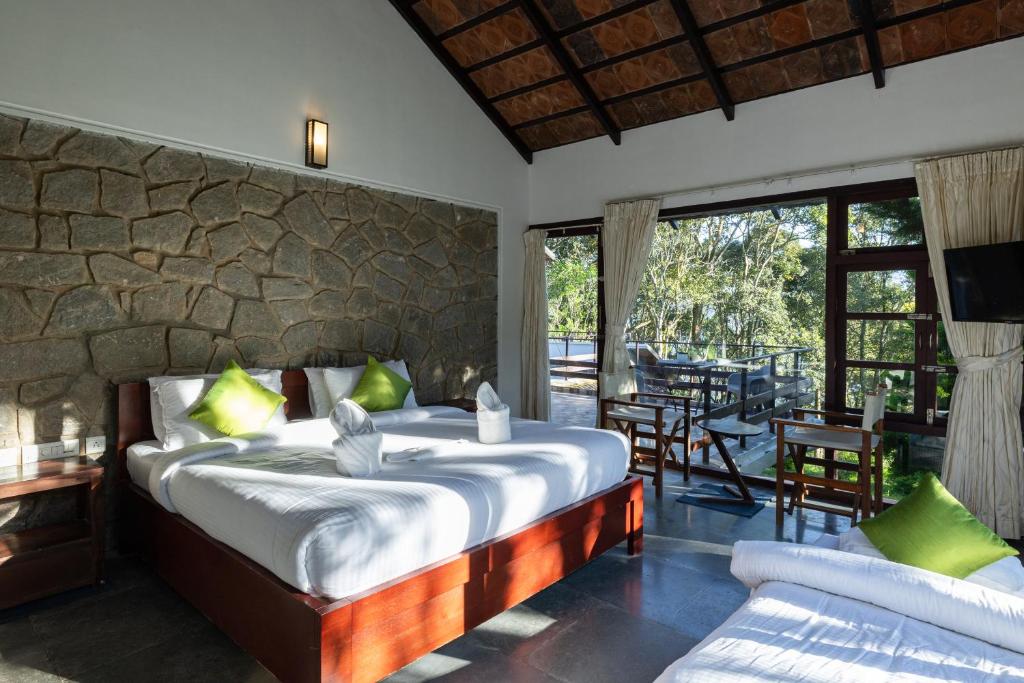钦纳卡纳Avadale Munnar (Stag Groups Not Allowed)的一间带床和石墙的卧室