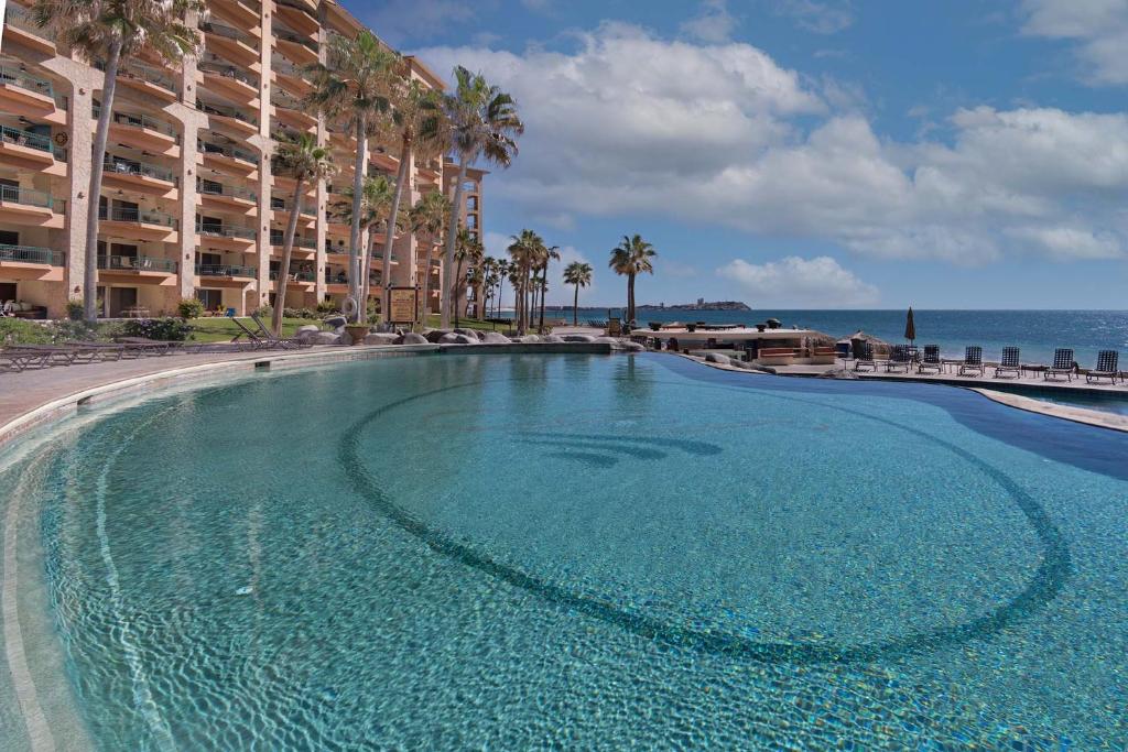 a large swimming pool in front of a large building at Wait 'n Sea Retreat Spacious Oceanfront Condo in Puerto Peñasco
