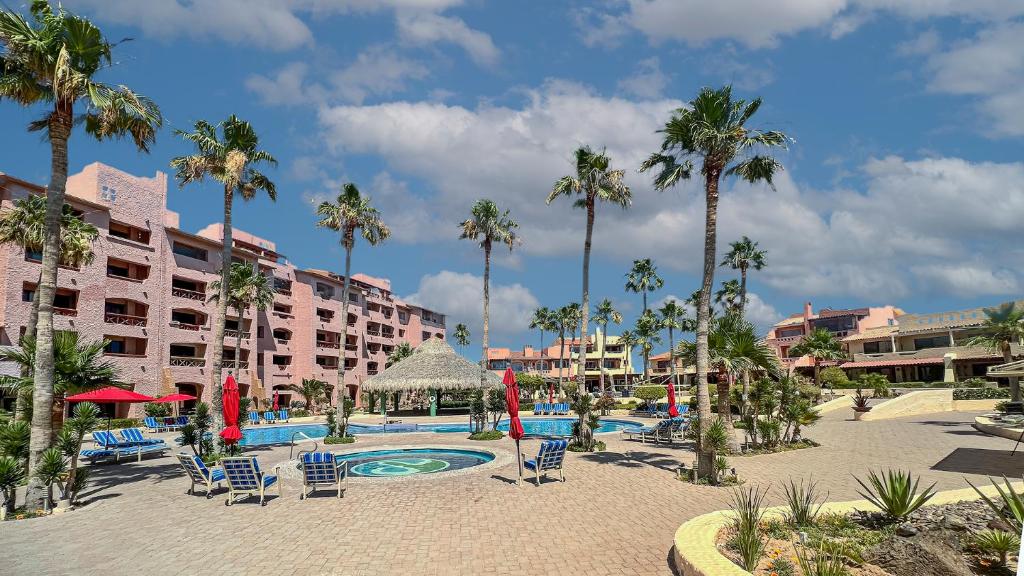 a resort with a pool and chairs and palm trees at Marina Pinacate 105 A License To Chill Pool-Side in Puerto Peñasco