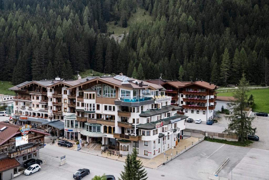 an aerial view of a large building with a parking lot at Hotel Neuhintertux in Tux