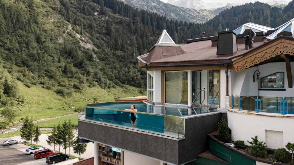 a house with a swimming pool on top of it at Hotel Neuhintertux in Tux