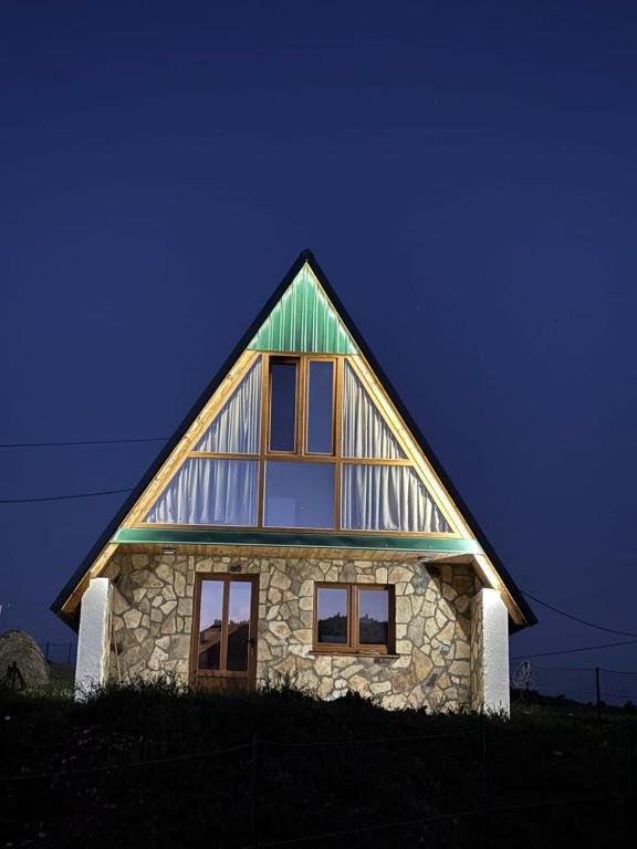 a large stone house with a green roof at Village house Gutovic in Rudinice