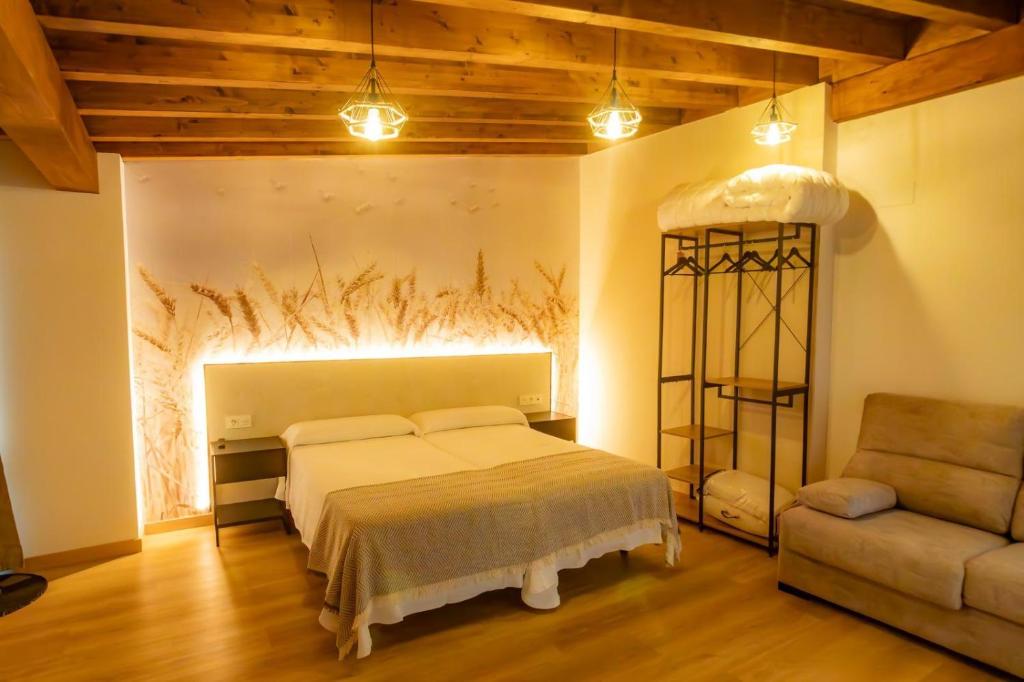 a bedroom with a bed and a couch at HOSTAL BOUTIQUE CAZORLA BAKERY in Cazorla