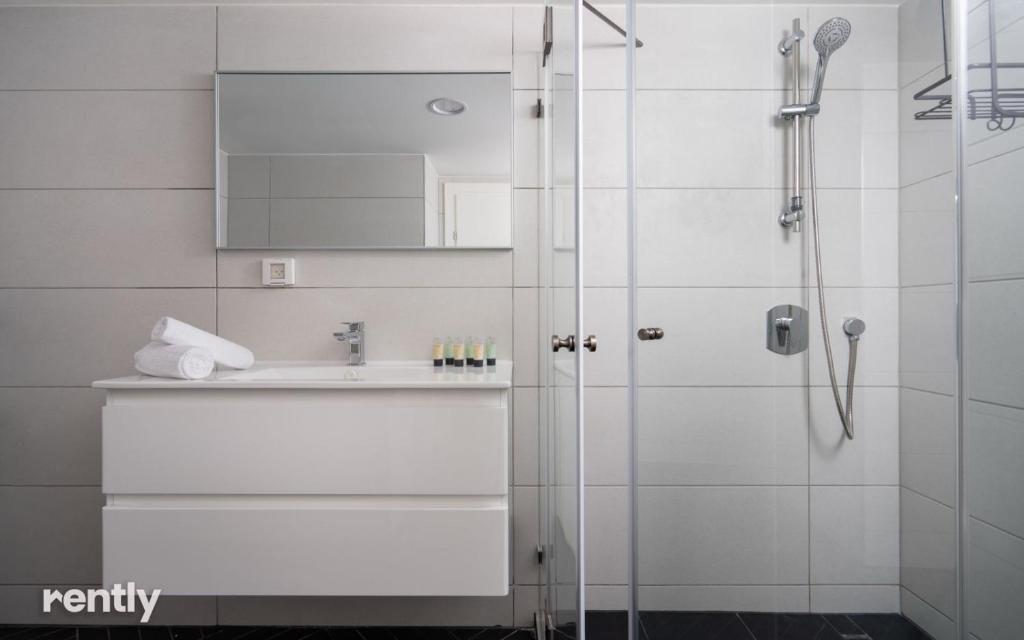 ein Badezimmer mit Dusche und Waschbecken in der Unterkunft Luxury Apartments And Studios At Sea Side By Rently in Eilat
