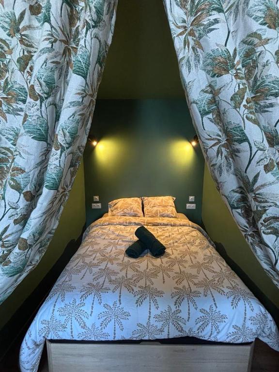 a bed with a pair of black shoes on it at Petite pause en centre ville avec parking in Lorient