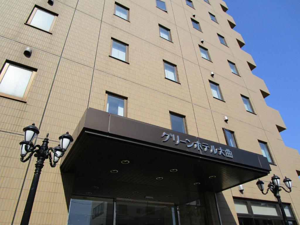 un edificio con una señal delante de él en Green Hotel Omagari, en Daisen