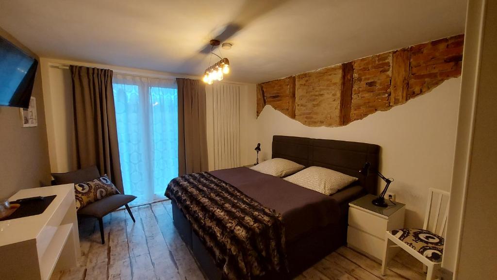 a bedroom with a bed and a couch and a television at Holl & Boll in Clausthal-Zellerfeld