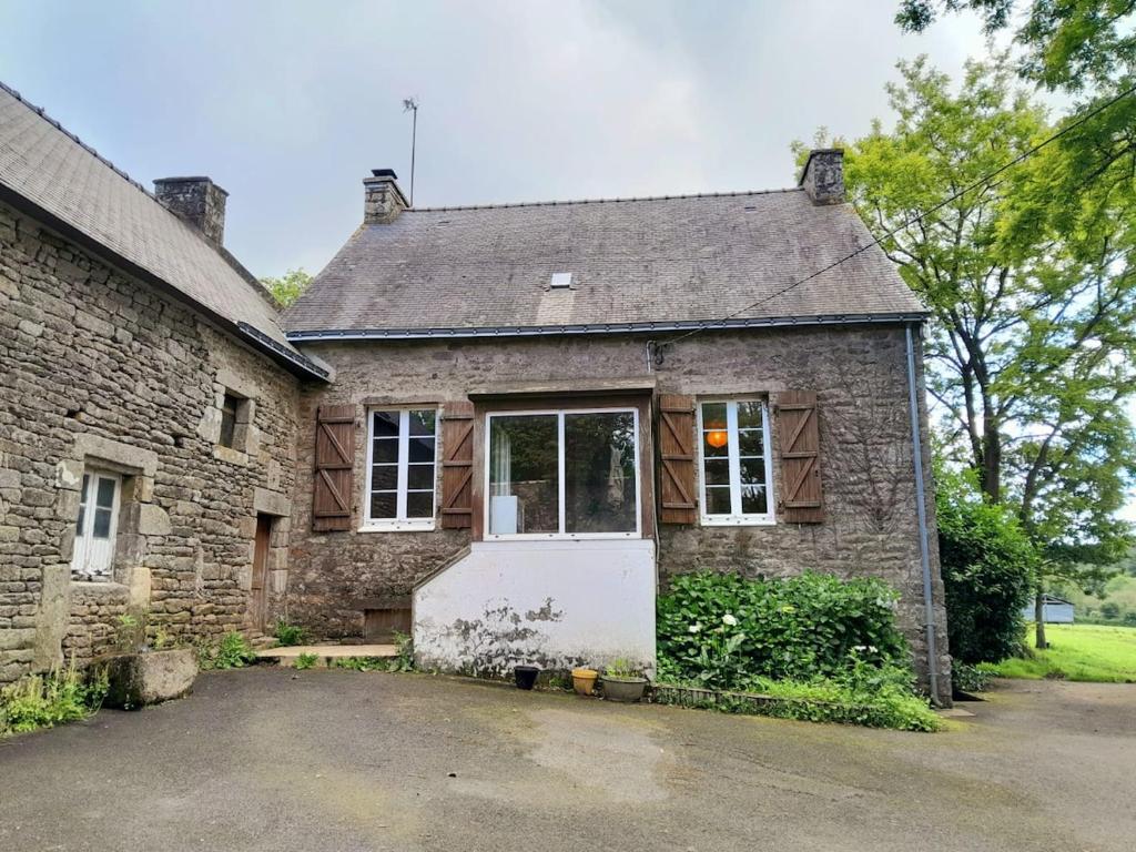 an old brick house with a white door at Maison de Campagne in Treffléan