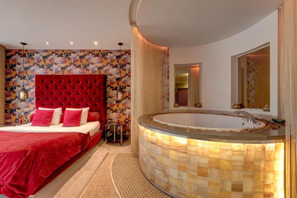 a bedroom with a bed and a bath tub at SPA apartments in city centre in Vilnius
