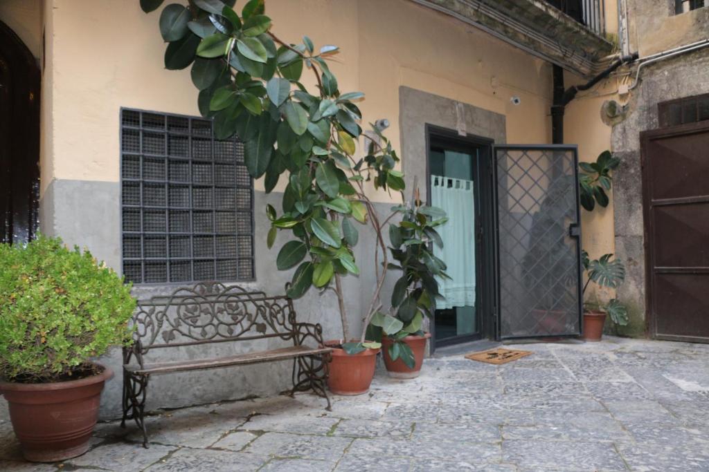 a bench sitting in front of a building with potted plants at The Lodge in Naples