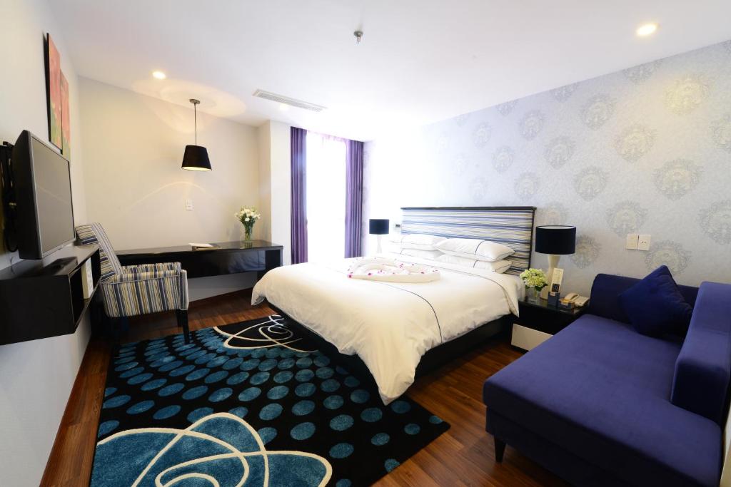 um quarto de hotel com uma cama e um sofá em Hanoi Emerald Waters Hotel & Spa em Hanói