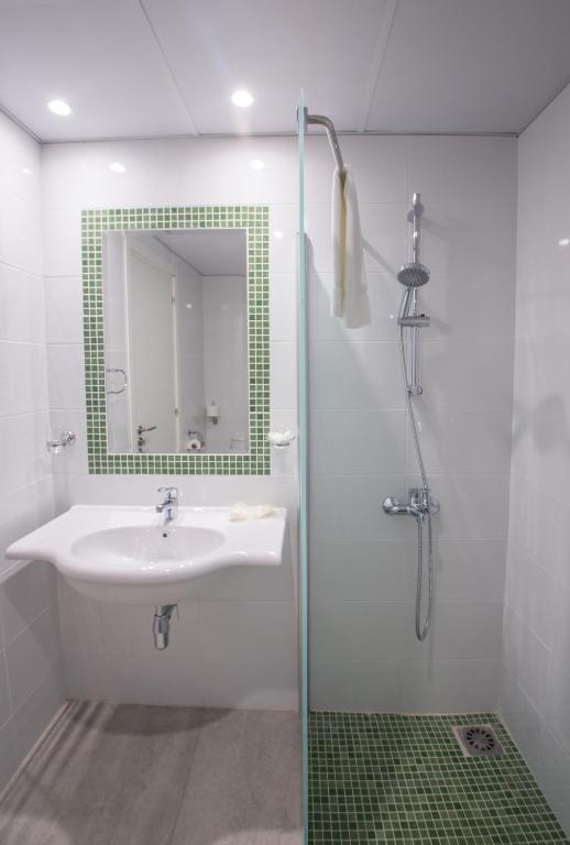a bathroom with a sink and a shower with a mirror at Nicholas Color Hotel in Ayia Napa