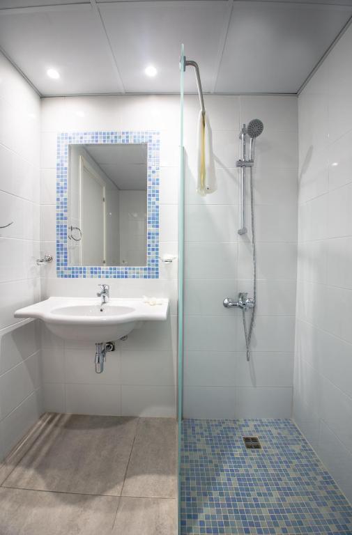 a bathroom with a sink and a shower with a mirror at Nicholas Color Hotel in Ayia Napa