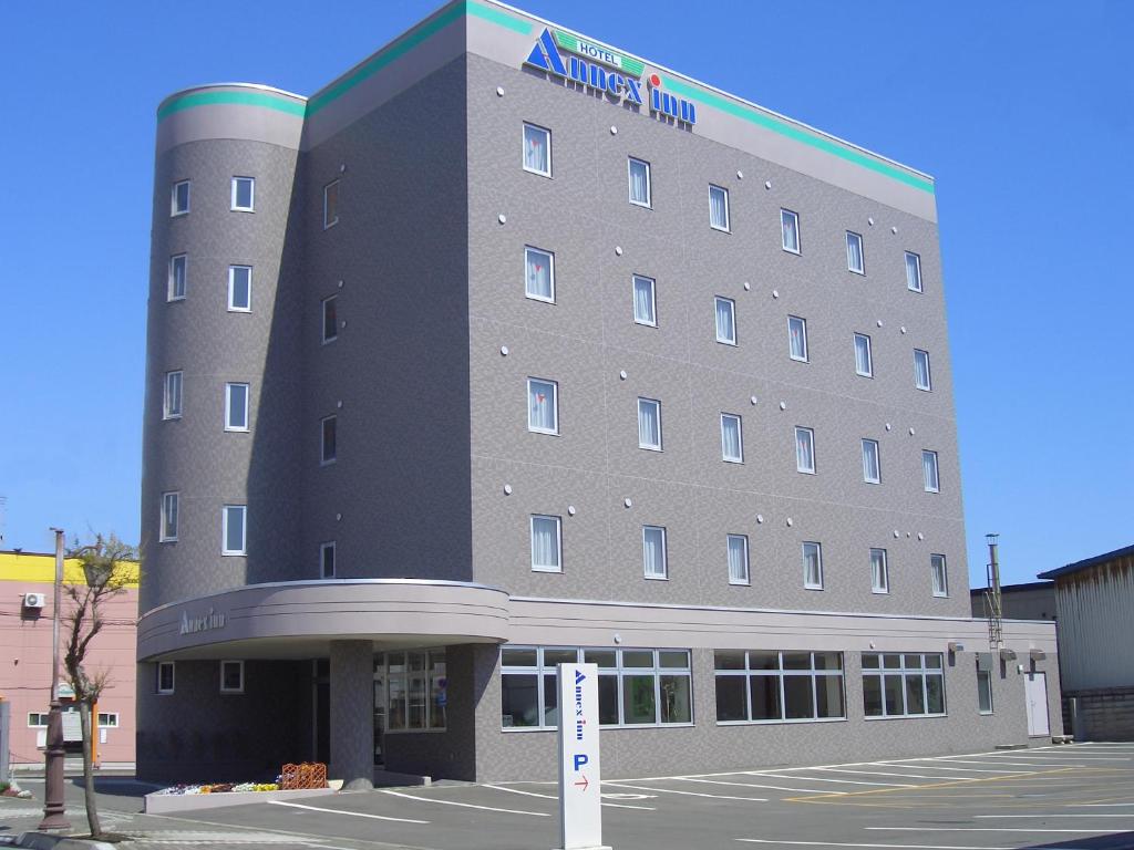 un edificio de hotel con un cartel delante en Hotel Annex Inn, en Shinhidaka