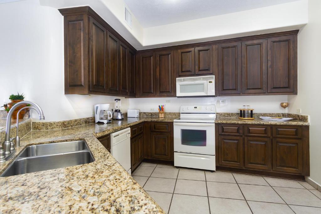 a kitchen with wooden cabinets and a sink at Bella Sirena in La Choya