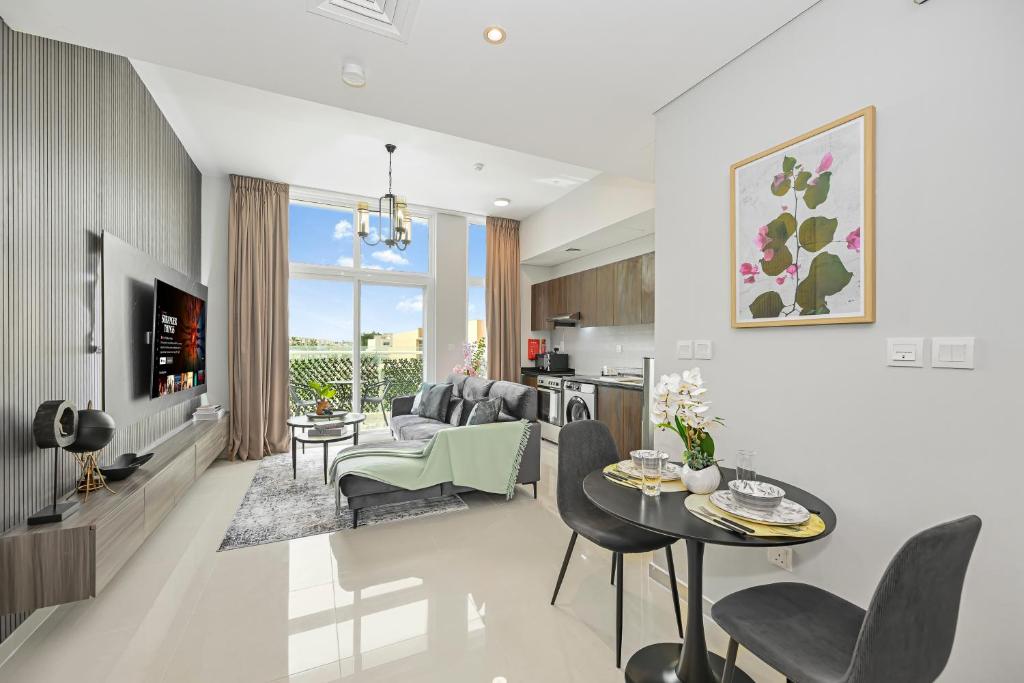 a living room with a couch and a table at Modern 1 Bedroom Apartment in Damac Hills 2 in Dubai
